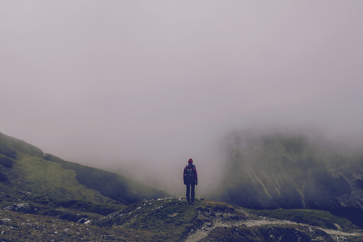 Figure on cloudy mountain top